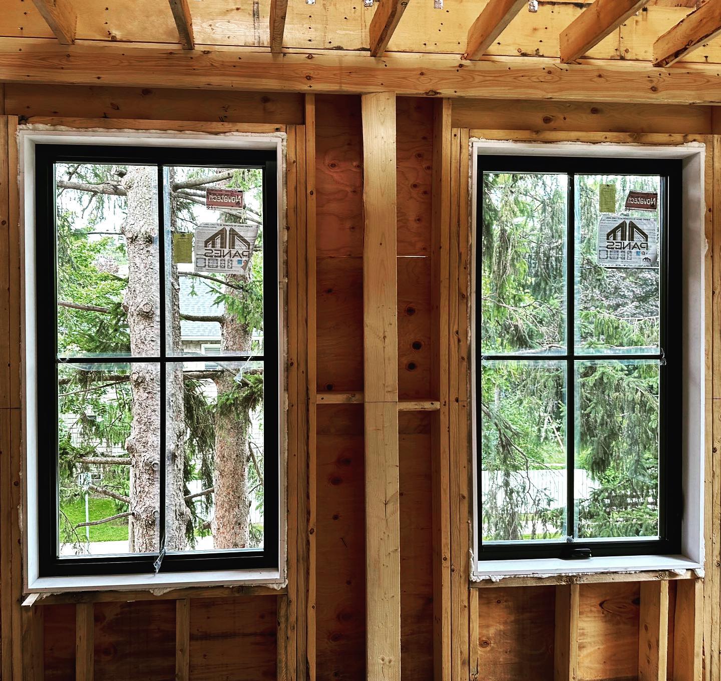 Two black Panes windows with grille divisions in an unfinished Aurora, Ontario building